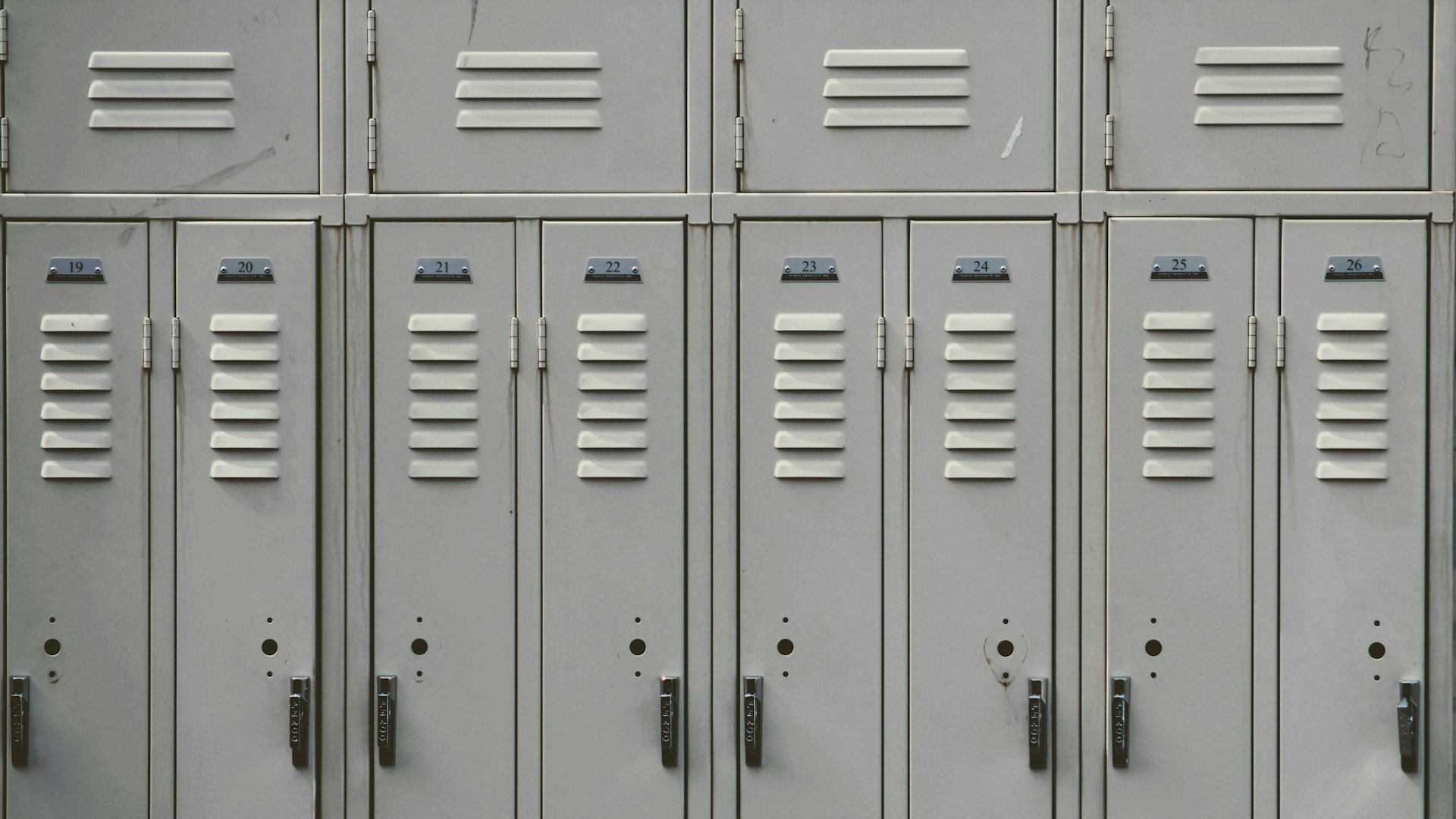 Sports equipment room with helmets and gear organized on shelves in a high school athletic department